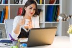 Pretty Young Woman Working With Laptop In Her Office Stock Photo