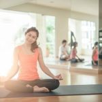 Asian Woman Doing Yoga Indoors Stock Photo