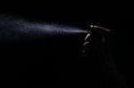 Perfume Spraying On Black Background Stock Photo