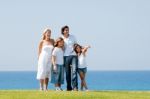 Happy Family Standing On Meadow Stock Photo