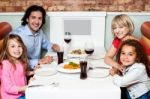 Cheerful Family Of Four In A Restaurant Stock Photo