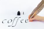 Hand Writing The Word Coffee With A Feather.jpg Stock Photo