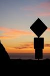 Road Sign Silhouette And Colorful Sunset Stock Photo