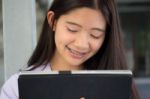 Portrait Of Thai Student Teen Beautiful Girl Using Her Tablet Stock Photo