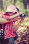 Mother Teaching Lovely Asian Daughter Taking Photos. Outdoors Stock Photo