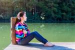 Young Girl Sitting On A Pier Stock Photo