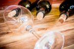 Red Wine Bottle, Glass And Grape Shaped Corks On Wooden Table Stock Photo