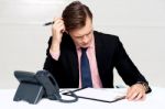 Confused Young Man Itching His Head With Pen Stock Photo