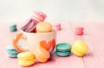 French Macarons In Cup On Pink Wooden Background.toned Image Stock Photo