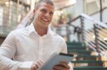 Smiling Man With Tablet Computer In Modern Business Building Stock Photo