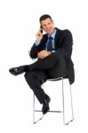 Businessman Sat Talking On Mobile Phone Stock Photo