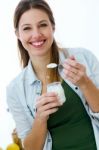 Pretty Young Woman Eating Yogurt In The Kitchen Stock Photo