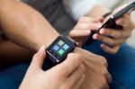 Beautiful Young Couple Using A Smartwatch At Home Stock Photo