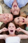 Family Members Lying On The Carpet Stock Photo