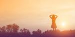 Silhouette Of Woman Praying Over Beautiful Sky Background Stock Photo