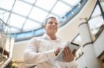 Man With Tablet Computer In Modern Business Building Stock Photo