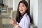 Portrait Of Thai Student Teen Beautiful Girl Using Her Phone And Smile Stock Photo