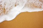 Sea Wave With Foam On Sand Stock Photo