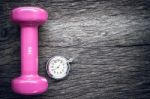 Time For Exercising Pocket Watch And Dumbbell On Wooden Background Stock Photo