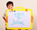 Little Boy Smiling With A Whitebaord Stock Photo