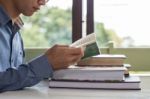 Business Man Sitting At A Table Reading A Book Stock Photo