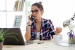 Pretty Young Woman Using Her Mobile Phone In The Office Stock Photo