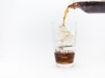 Cola Pouring From A Plastic Bottle Into A Glass Filled With Ice Cubes Stock Photo