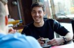 Group Of Friends Using Mobile Phone In Cafe Stock Photo