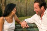 Couples Sat Hand In Hand And Smile Stock Photo