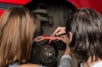 Auto Mechanic And Female Trainee Changing A Car Tyre In Garage Stock Photo