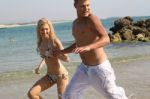 Young Couple Running At Beach Stock Photo