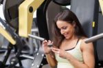 Woman Using Mobile Phone On A Break In Health Club Stock Photo