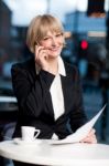 Manager Communicating Via Cell Phone In Cafe Stock Photo