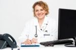 Female Doctor Writing On Clipboard Stock Photo