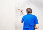 Worker Painting Wall With Background Glue For A Wallpaper Stock Photo