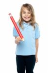 Charming Kid With Beautiful Hair Holding Red Pencil Stock Photo