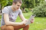 Man With Tablet Computer In Park Stock Photo