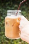 Hand On Glass Of Iced Milk Coffee With Vintage Filter Effect Stock Photo