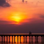 Silhouette Boy Ride Bicycle On The Bridge At Sunset Stock Photo