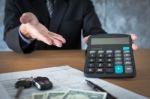 Car Salesman Holding A Key And Calculating A Price At The Dealer Stock Photo