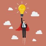 Businessman Superhero Holding Creative Lightbulb Stock Photo