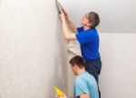 Two Workers Smoothing Wallpaper Stock Photo