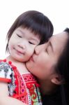 Mother Kissing Her Adorable Little Daughter Cheek, On White. Stu Stock Photo