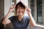 Portrait Of Thai Adult Beautiful Girl Reading Red Book Stock Photo