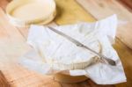 Camembert Cheese Wrapped In Paper With Vintage Knife On Wooden T Stock Photo