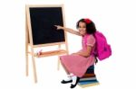 Cute Smiling Student Pointing At Blank Chalkboard Stock Photo