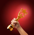 Star Award In Hand Isolated On Red Background Stock Photo