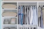 Clothes Hanging In White Wardrobe Stock Photo