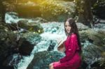 Summer Portrait Of Young  Women Enjoying Nature  In Tight Fitting Red Dress Summer Vacation,sunny,having Fun, Positive Mood,romantic, Against Background Of Summer Green Park, Green Leaves Stay Outdoor Stock Photo