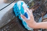 Male Hand Washing Brown Car With Blue Sponge And Bubbles (foam) Stock Photo